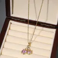 Detail of pink zircon cherry pendant with gold stem and white crystal on beige velvet - Pink Round Cherry Style (X2608)