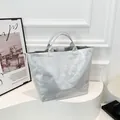 Sac fourre-tout argenté métallisé avec lettrage TOTE BAG sur un support blanc élégant - Argent