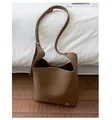 Détail du sac seau en cuir marron grainé avec un petit logo en métal argenté brillant - Marron