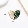 Detail of heart-shaped brooch with white pearls, green crystal, and 3x3.3cm dimensions - Pearl Green Gem Spliced Heart Style (XX0054)