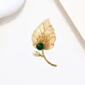 Detailed macro of golden leaf brooch with white pearl, green agate, and shell petals - Iridescent MOP Green Bead Leaf Style (XX0016)