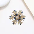Detailed macro view of rotating snowflake brooch with blue crystals and gold plating - Xx0143