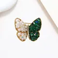 Close-up of golden butterfly brooch with white pearls and emerald green crystals - Emerald Gem Vintage Butterfly Style (XX0066)