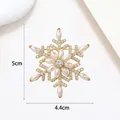 Detail view of a 5cm rotating snowflake brooch with pearls and crystals in gold finish - Xx0162