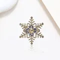 Macro detail of rotating snowflake brooch with sparkling gold-plated zircons on white base - Xx0187