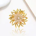 Close-up of golden spinning snowflake brooch with marquise stones and crystal details - Xx0198