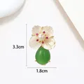 Macro view of flower brooch with pearl petal, red crystal accents and green drop pendant - Five Petal MOP Green Chalcedony Flower Style (XX0082)