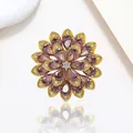 Detail of a rotating snowflake brooch with purple teardrop crystals on a gold-tone base - Xx0201
