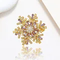 Detail of spinning snowflake brooch with purple baguette stones and gold finish - Xx0207