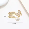 Close-up of golden butterfly brooch with zircon, shell texture, and white pearl details - Imitation MOP Twin Butterfly Dynamic Style (XX0157)