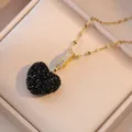 Macro shot of a black heart pendant with pavé crystals on a gold chain in a jewelry box - Black (X0427)