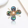 Elegant flower brooch with abalone shell petals and a white pearl center on white surface - Abalone Shell Iridescent Pearl Gold Twist Style (XX0190)