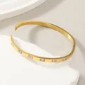 Detail of gold stainless steel bangle with rectangular cubic zirconia stones inlay - Rectangular Zirconia Gold Style (Gold)