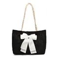 Chic black textured tote bag featuring a white bow and woven cream shoulder strap - Black