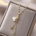 Gold-plated heart necklace with zircon bow and traditional Chinese coin pendants on grey box - Gold