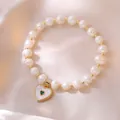 Eleganter Süßwasserperlen-Armband mit goldenem Herzanhänger und grünem Edelstein-Inlay - Goldene Herz Muschel Perlen Armband