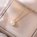 Détail d'un pendentif en perle d'eau douce dorée avec zircon sur une chaîne fine - Collier de perles d'eau douce