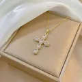 Close-up of golden cross pendant necklace with zircon stones on a satin background - Gold Tone Vintage White Zirconia (X3638)