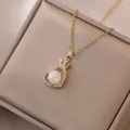 Dettaglio di collana a cuore dorata con corona, perla centrale e pietre di zircone - Collana a Cuore (X0314)