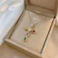 Detailed shot of a colorful zircon cross pendant necklace displayed in a beige jewelry gift box - Gold Tone Multicolor Zirconia Cross (X1329)