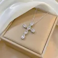 Close-up of silver cross pendant with sparkling zircons on elegant silk background - Silver Tone Clear Zirconia Cross (X1328)