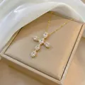 Detailed view of a gold cross pendant necklace with marquise-cut crystals on silk fabric - Gold Tone Clear Zirconia Cross (X1327)