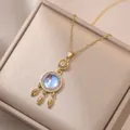 Golden dreamcatcher pendant necklace with blue moonstone and leaf charms in a box - Dreamcatcher Pendant Necklace (X0362) / Gold