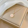 Dettaglio macro del ciondolo a margherita dorata con petali rosa e perla centrale - Collana Fiore Rotante (X0394)