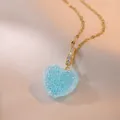 Elegant gold heart pendant necklace featuring blue crystals on champagne satin background - Blue (X0423)