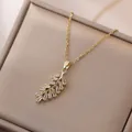Elegante collana dorata con ciondolo a foglia in zircone su una catena sottile - Collana Piuma d'Oro