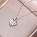 Macro shot of silver heart pendant featuring multi-shape crystal inlay on a silk box - Fancy White Zirconia Style (X1569)