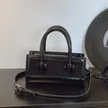 Γυαλιστερή μαύρη ορθογώνια τσάντα από λουστρίνι με κυλινδρικές λαβές και λουρί - Μαύρο