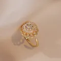 Anello girasole dorato con zirconi cubici su elegante sfondo di seta beige - Anello Stile Girasole (J0103) / Oro Rotante