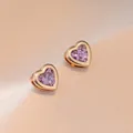 Élégantes boucles d'oreilles cœur en or avec zircons violets facettés sur tissu beige - Boucles d'Oreilles Coeur Violet