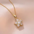 Macro view of gold star pendant necklace with white zircons on champagne silk fabric - Gold