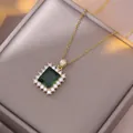 Elegante collana in titanio dorato con zircone smeraldo quadrato e bordo di diamanti halo - Collana a Catena Incrociata Verde Smeraldo