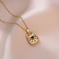Elegant gold necklace with handbag pendant, heart green gemstone and white crystals - Gold