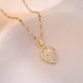 Elegant gold leaf pendant necklace with white gemstone and zircons on silk background - Gold