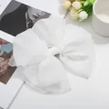 Gros plan d'une grande pince à cheveux nœud en tulle blanc avec texture en maille fine - Blanc