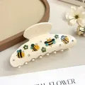 Dettaglio di un mollettone per capelli crema con ape, fiore verde e piccoli strass - Quattro Api