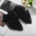 Grande barrette nœud élégante en résille noire avec tissu multicouche sur fond minimaliste - Noir