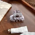 Detail einer herzförmigen Haarklammer aus Acetat mit Marmortextur auf einem Holztablett - Graurosa 6.5cm