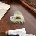 Nahaufnahme einer herzförmigen Haarklammer mit Polarlicht-Effekt auf Holztablett - Geleegrün 6.5cm