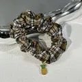 Elegant plaid scrunchie with yellow enamel pineapple charm on gray textured background - Small Scrunchie