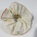Beige scrunchie with orange piping and a Happiness lemon tag for stylish bun hairstyles - Orange with Light Yellow Trim
