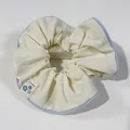Chic beige scrunchie with light blue piping and a floral fabric brand tag - Blue with Light Yellow Trim