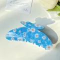Light blue floral hair claw clip with white daisies and orange centers on white desk - 11cm Daisy Blue