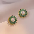 Gouden zonnebloem oorbellen met groene marquise kristallen en witte zirkonia details - Smaragd zonnebloem roterende oorbellen
