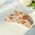 Large hair claw clip featuring white translucent finish and orange floral print patterns - 11cm Orange
