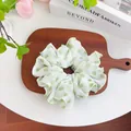 Close-up of light green polka dot tulle scrunchie on a tray with decorative props - Big Polka Dot Scrunchie